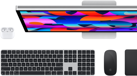 عرض من الأعلى لشاشة Studio Display، لوحة مفاتيح Magic سوداء، فأرة Magic سوداء، لوحة تتبع Magic سوداء، وعلبة AirPods بيضاء